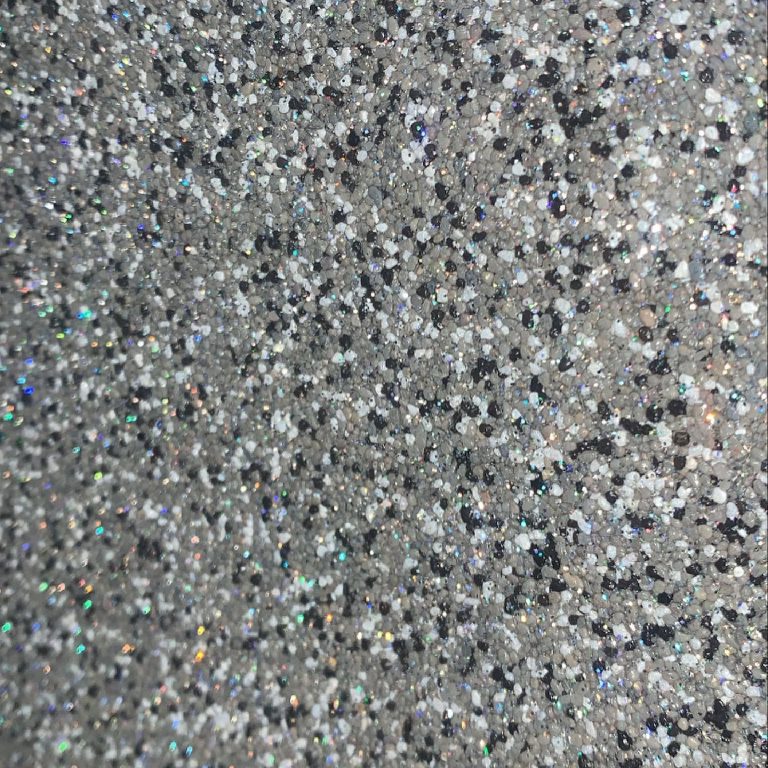 Close range: the stone aggregate, with the flake catching light through it.