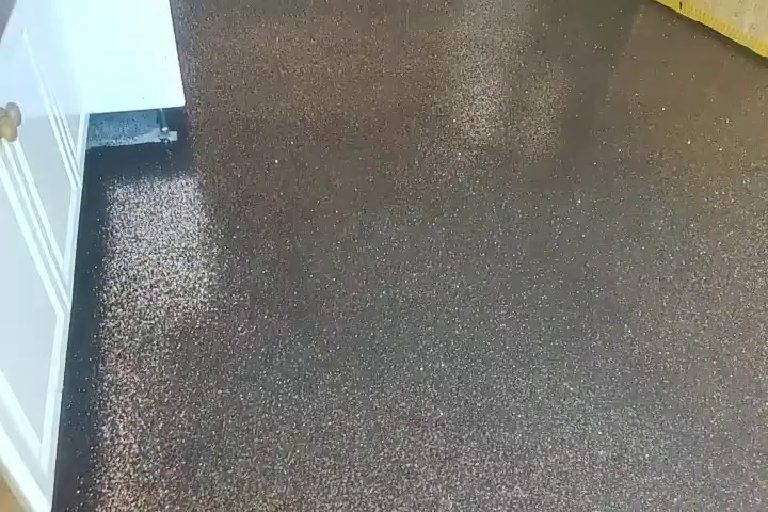 The black and bronze floor running through a doorway.