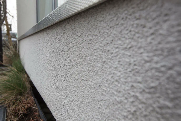 A cork rendered wall raking away from the camera, the granulated surface clean and even