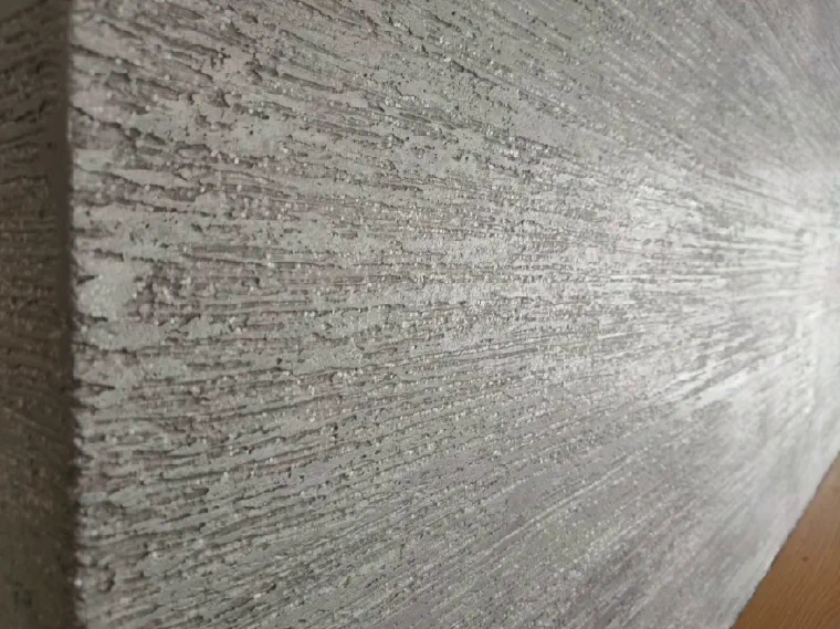 A grey plastered fire breast with a hint of glitter, catching the light from one side
