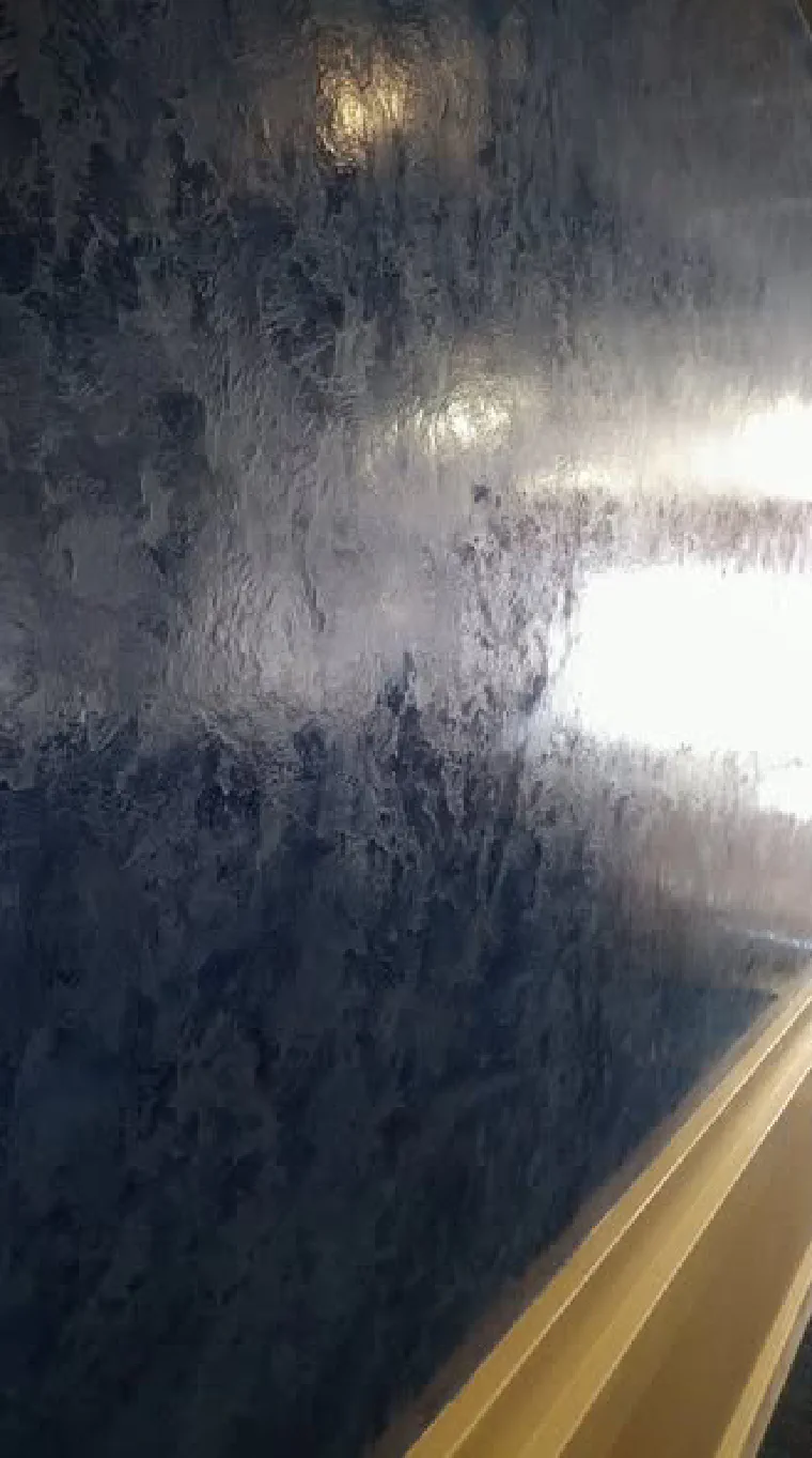 A deep blue plaster panel burnished until the surface reflects the room
