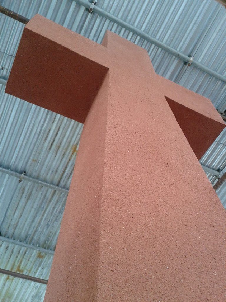 The cross arms in finished terracotta render, every edge kept sharp
