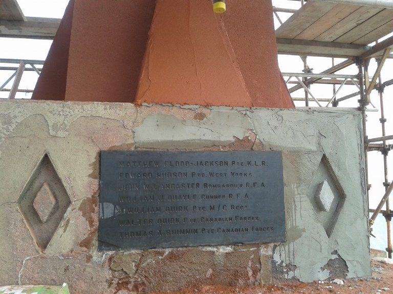 The original red stone plinth being made good, the shaft above already rendered terracotta