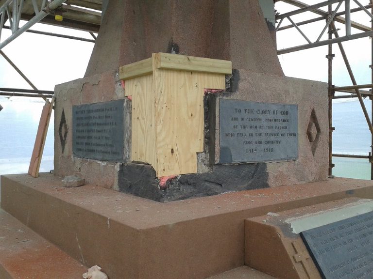 Timber shuttering fixed to the rebuilt corner of the base while the mortar sets