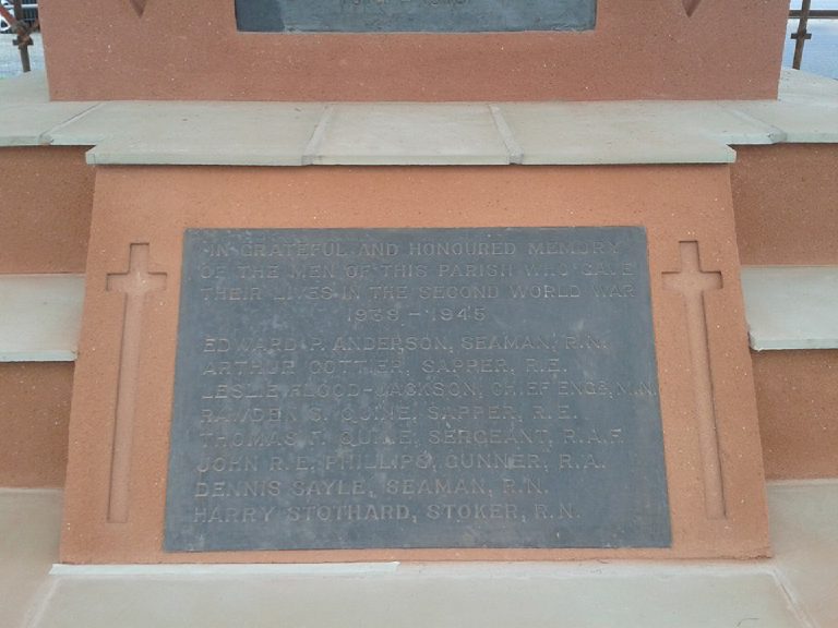 The Second World War plaque set in the terracotta render, with a slim cross recessed either side of it