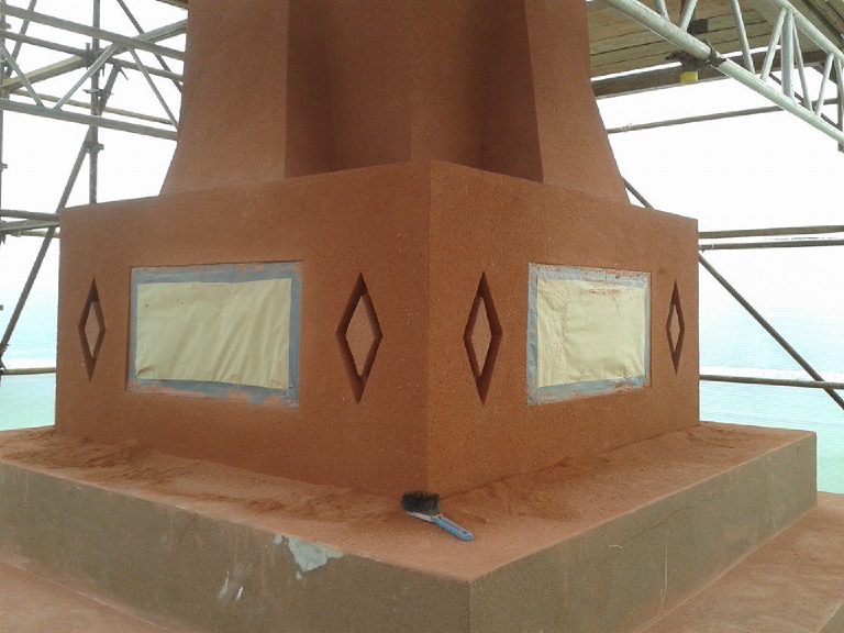 The plinth in finished terracotta render, plaques still masked off