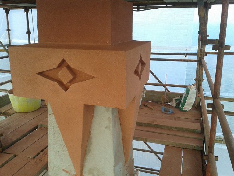 Recessed four point crosses in the terracotta render on the capital, seen from the scaffold