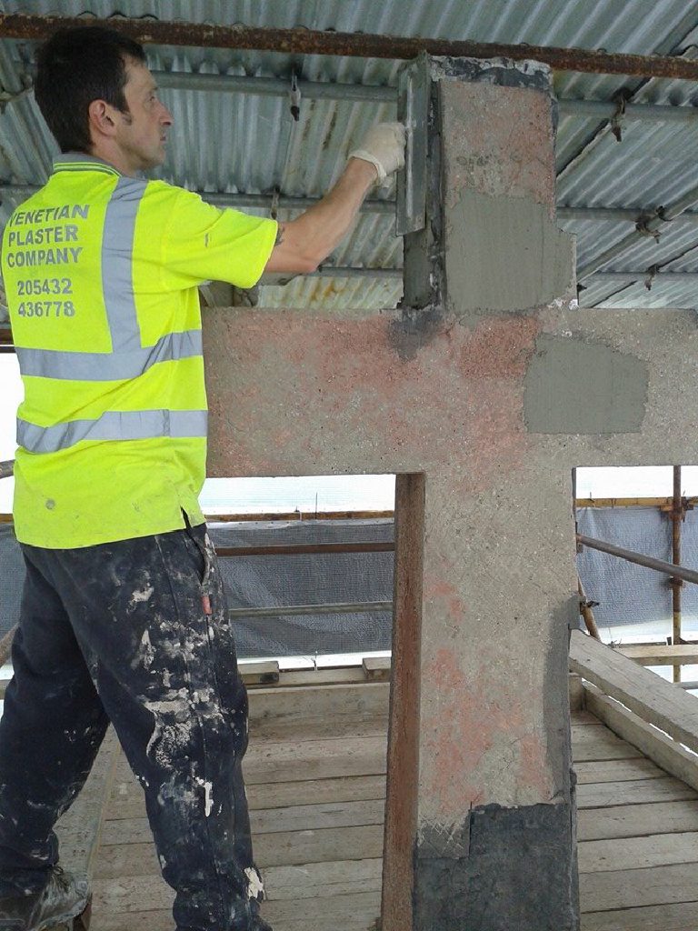 A Venetian Plaster Company man working mortar into the bare cross before any render goes on