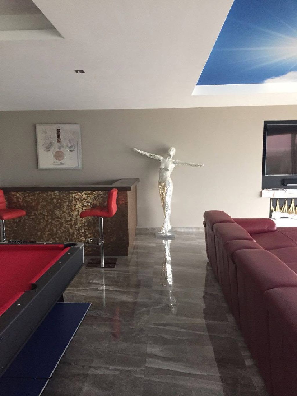 The finished room — bronze bar, red pool table and the sky ceiling