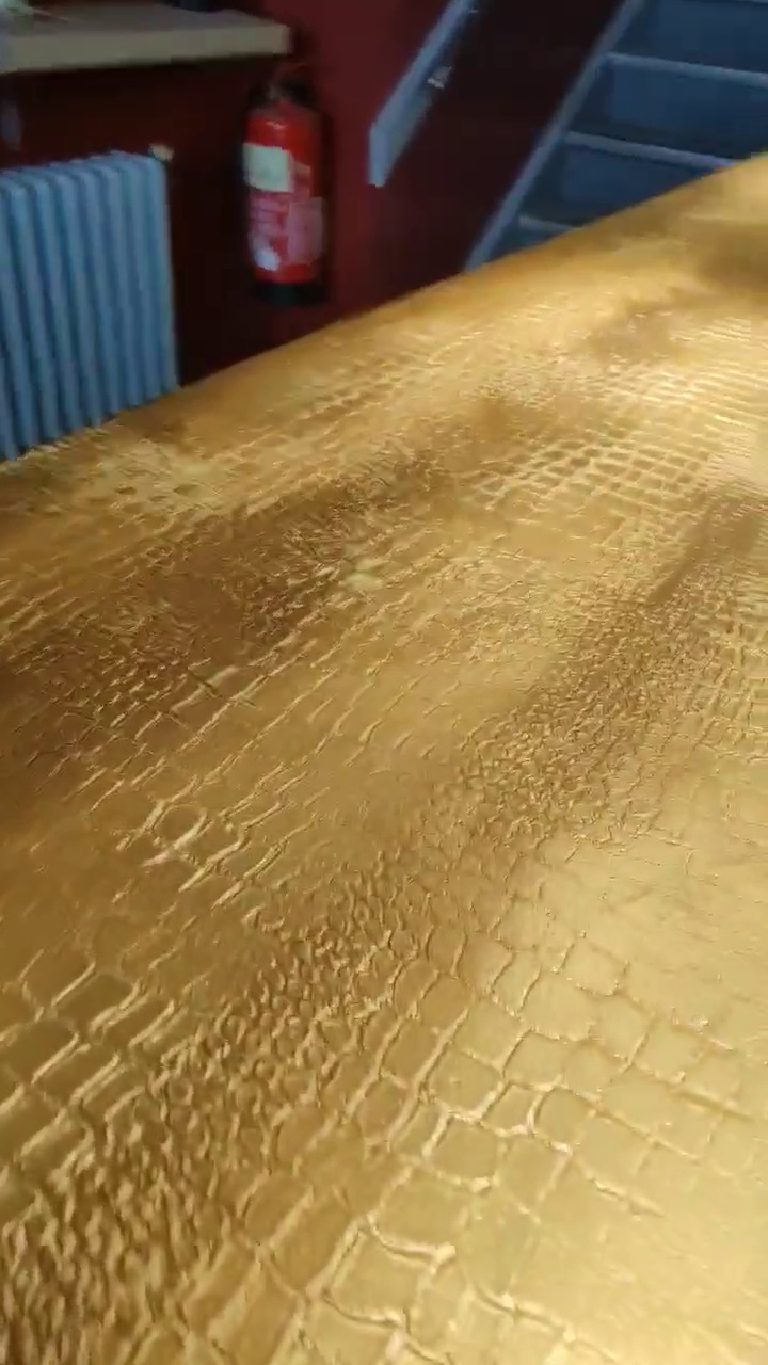 The rounded front edge of the bar top with the crocodile print carrying over it