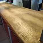 The bar top running the length of the room, the crocodile print catching the light along the whole run