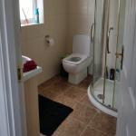 The same bathroom before, tiled cream on the walls and brown on the floor