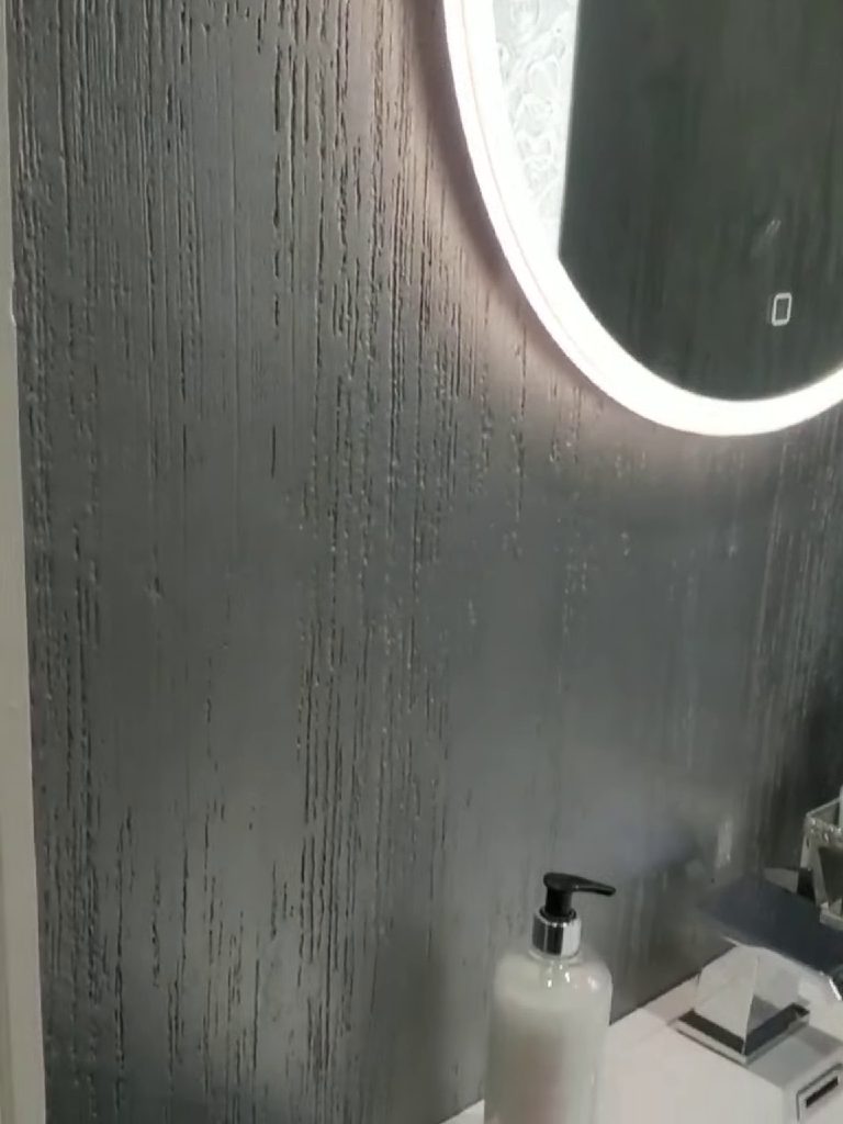 The metallic silver plaster under the glow of the mirror light