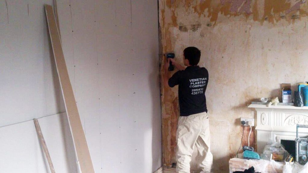 Fixing plasterboards ready for skimming