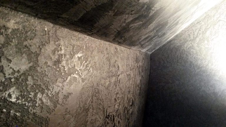 Applying black Marmorino plaster to walls and ceiling