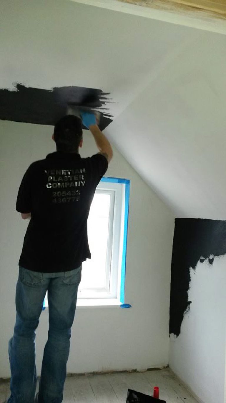Applying black Marmorino plaster to walls and ceiling