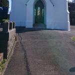 The front elevation finished, bell in the tower opening and stained glass in the door