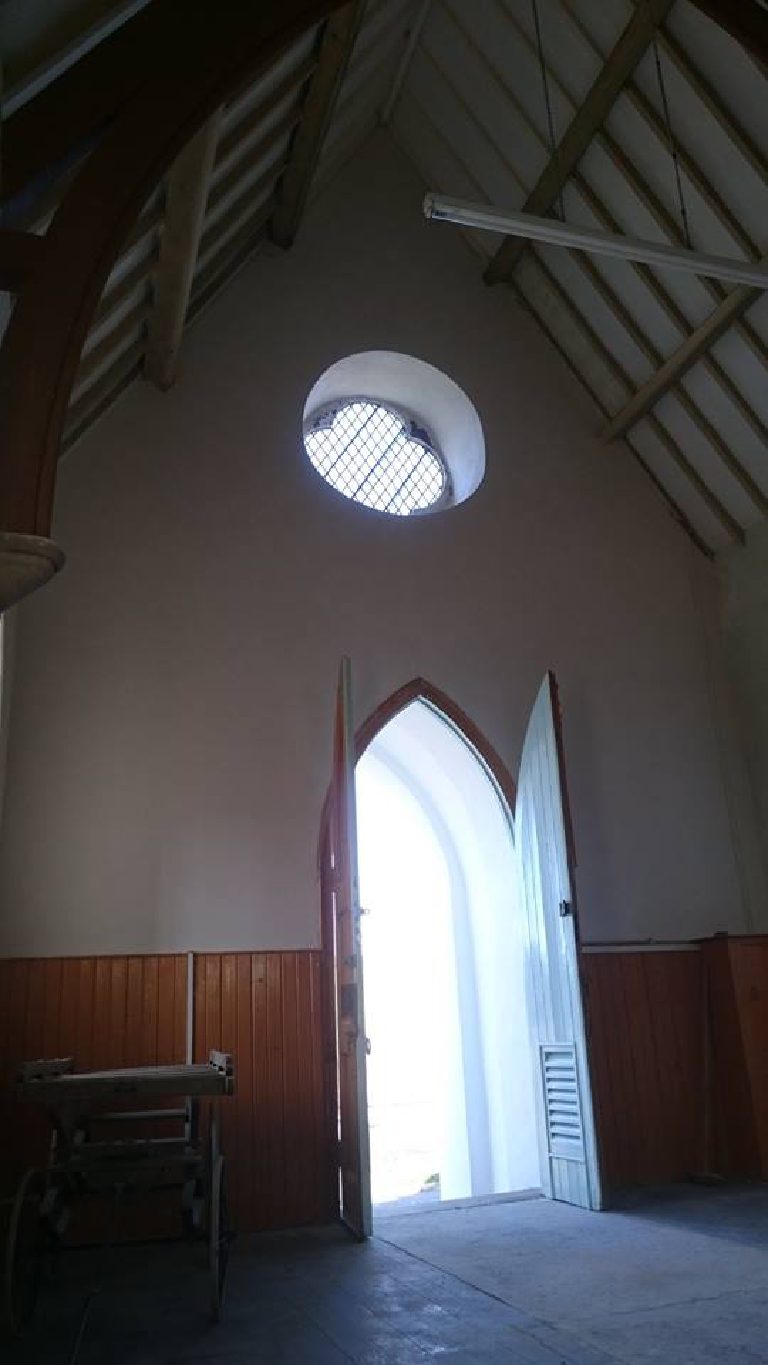 The round leaded window and open roof timbers, walls made good below