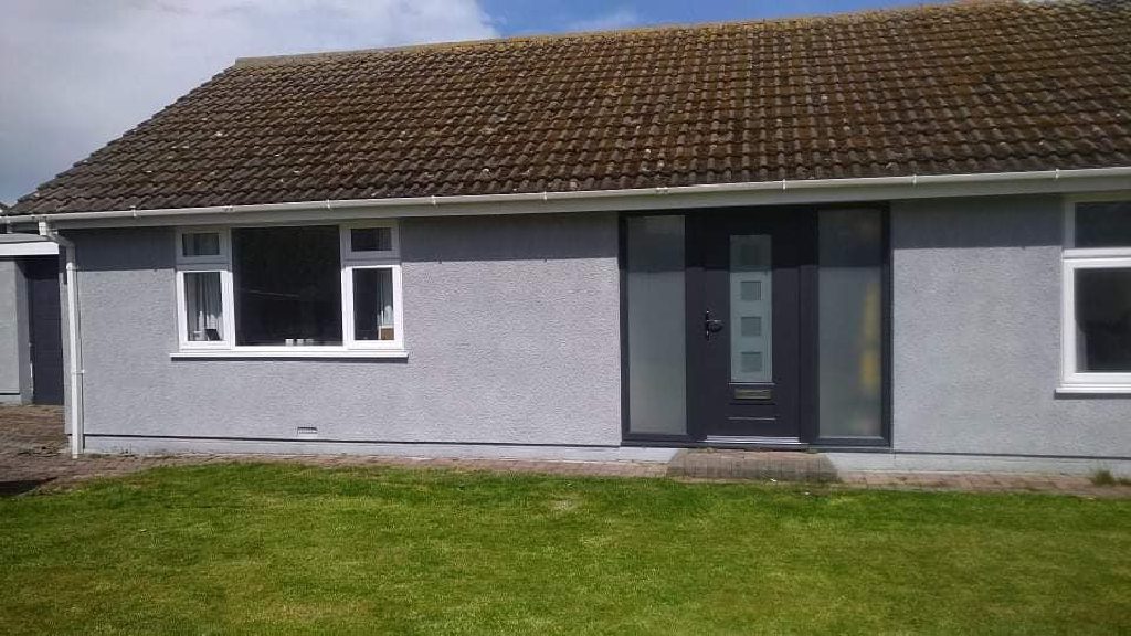 The front elevation of the bungalow after, in grey cork render
