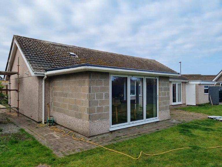 The rear before, with the new extension still in bare blockwork and the old gable in spar dash, scaffold to the left