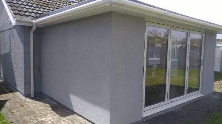 The corner of the finished extension, render running up to the fascia and round to the bifold doors
