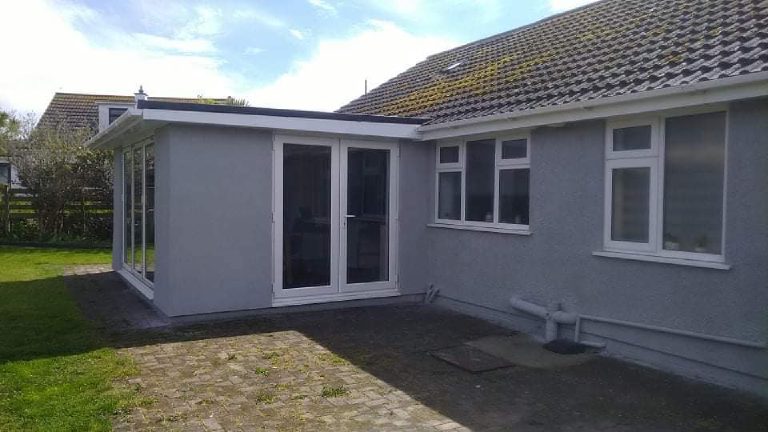 The rear extension and the original bungalow wall, both finished in the same grey render