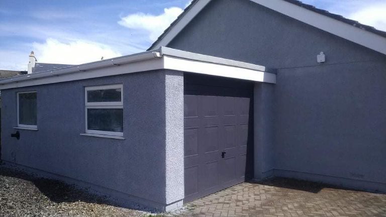 The finished garage in grey render with the up-and-over door in the same grey
