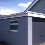 The garage after, rendered grey with the up-and-over door in the same grey