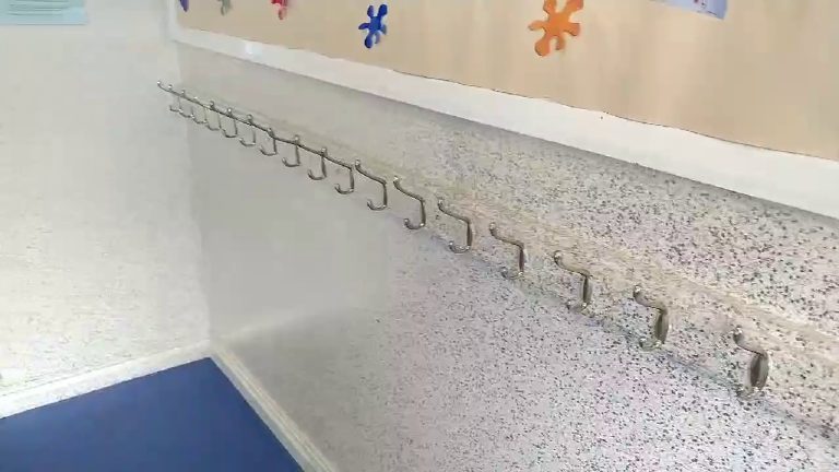 The coat hook run seen along the corridor above the blue floor