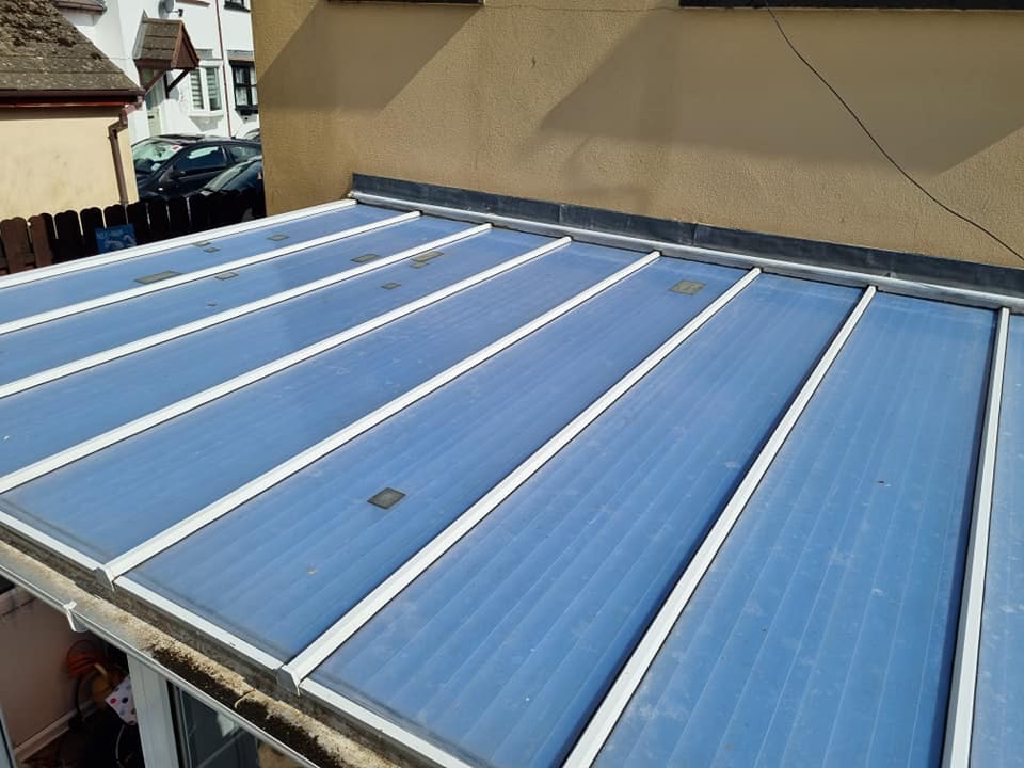 The old blue polycarbonate conservatory roof before the work