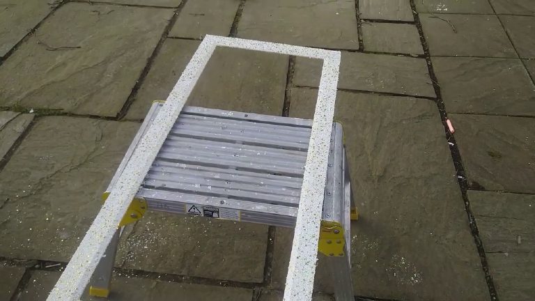 The old picture frame sprayed white with gold flakes, drying on a step-up
