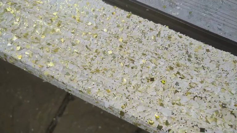 The gold flakes across the moulding of the frame, up close
