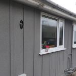 The finished bungalow in grey ThermoCork render, windows and sills picked out in white