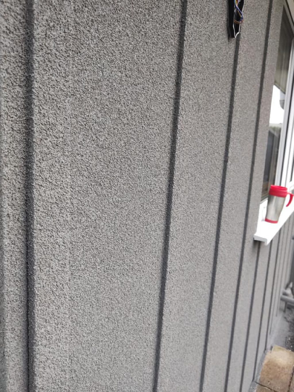 The sprayed cork render up close, with the cladding lines running through it