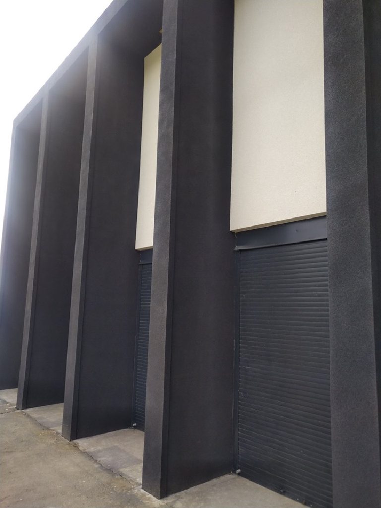 The pale panels set between the dark rendered piers