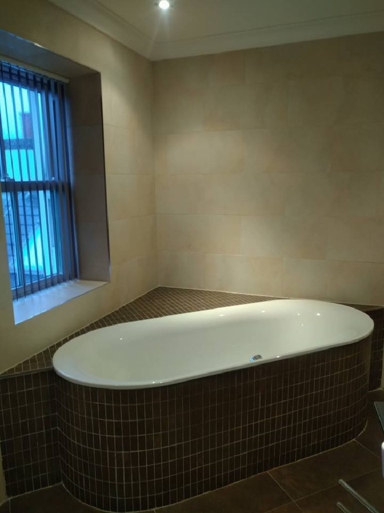 The bath in its dark mosaic tiled surround before the work