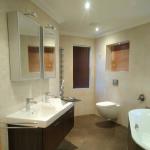 The same bathroom before, fully tiled in cream ceramic