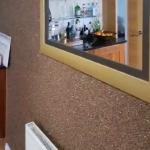 The kitchen feature wall in dark bronze Crystal Quartz, taken up to the coving, with a framed mirror on it