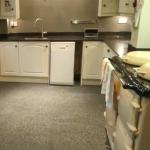 The finished kitchen looking towards the sink, with the stone finish running from wall to floor