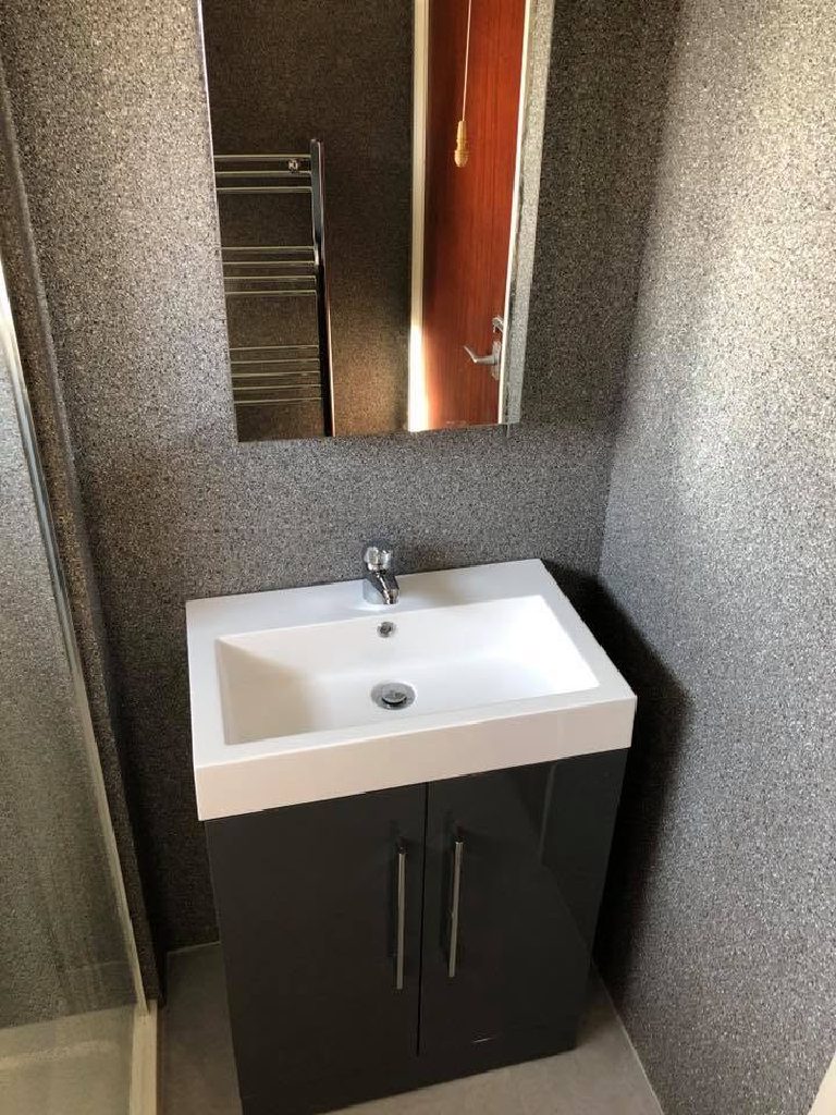 The basin unit and mirror against the grey quartz
