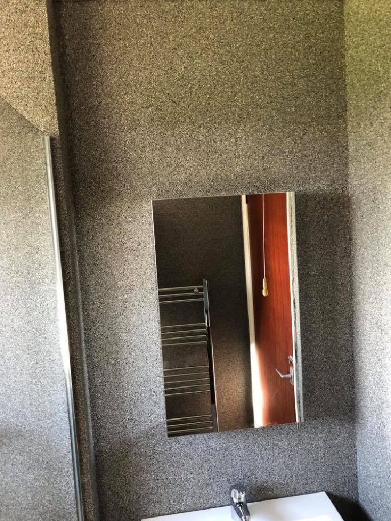 The mirror and heated towel rail on the quartz wall