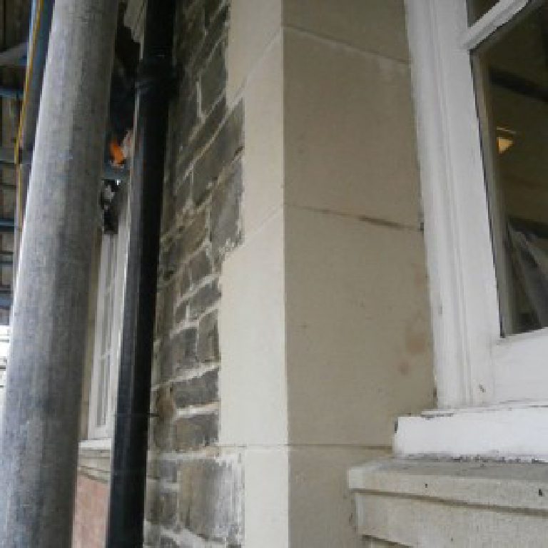 A corner pier mid-repair behind the scaffolding