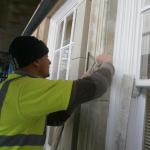 Craftsman in hi-vis carefully dressing new stone around a window at Douglas Town Hall