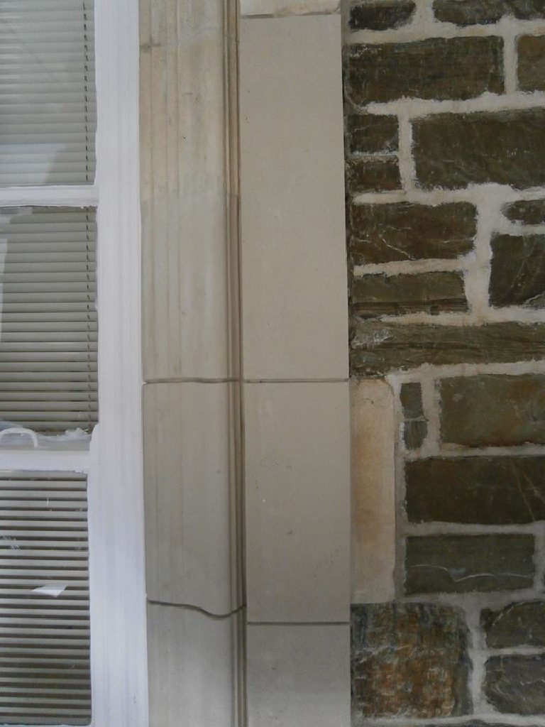 New squared stone pieced in beside the original fluted window jamb