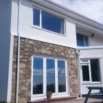 The finished exterior at Bradda Head, white render and stone detailing