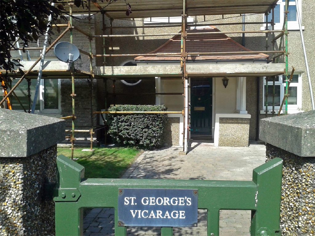 St George's Vicarage name plaque with the refurbished pebbledashed exterior behind
