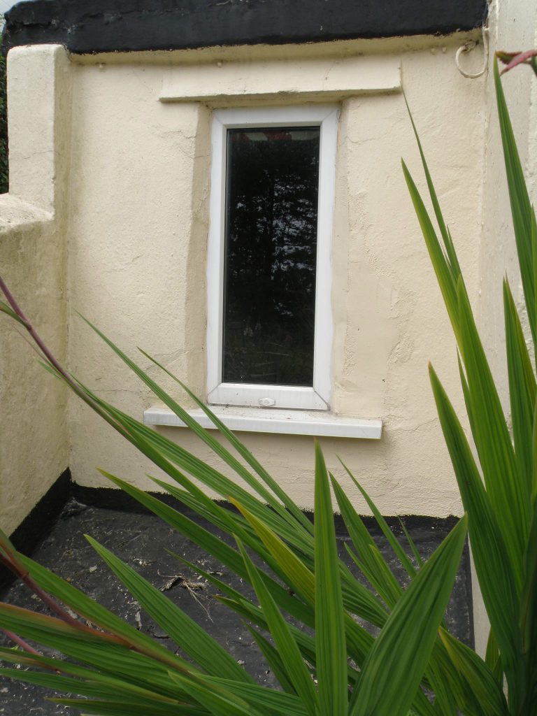 Cracked, patchy render around window before work
