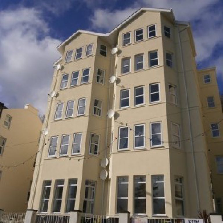 Full frontage of Falcon Cliff Apartments in fresh cream render