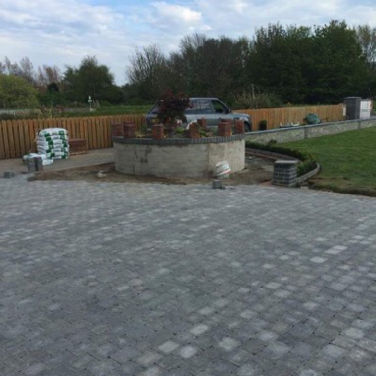 The bed part built in bare blockwork, block paving going down across the drive and materials stacked at the side