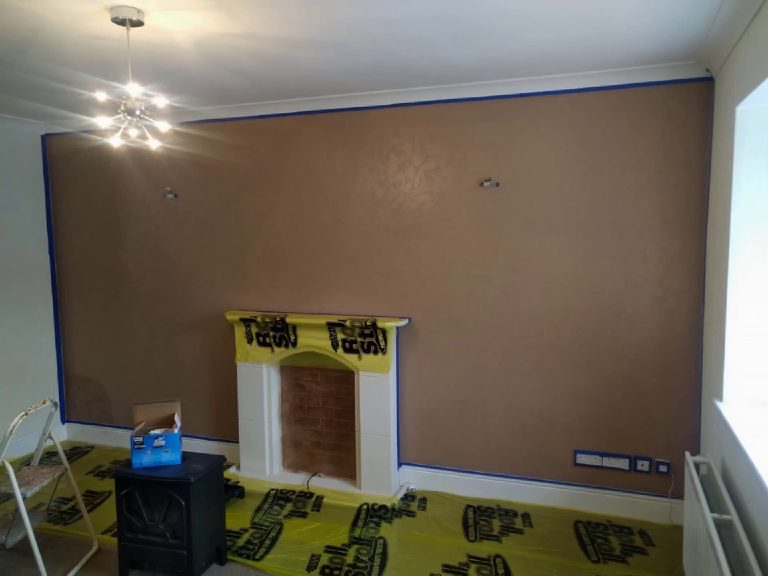 The chimney breast wall in base coat, masked up with the floor protected and the stove waiting